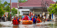 A rescue team evacuates women and children.