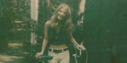 Rhonda Marie Fisher posing with a bike and smiling.